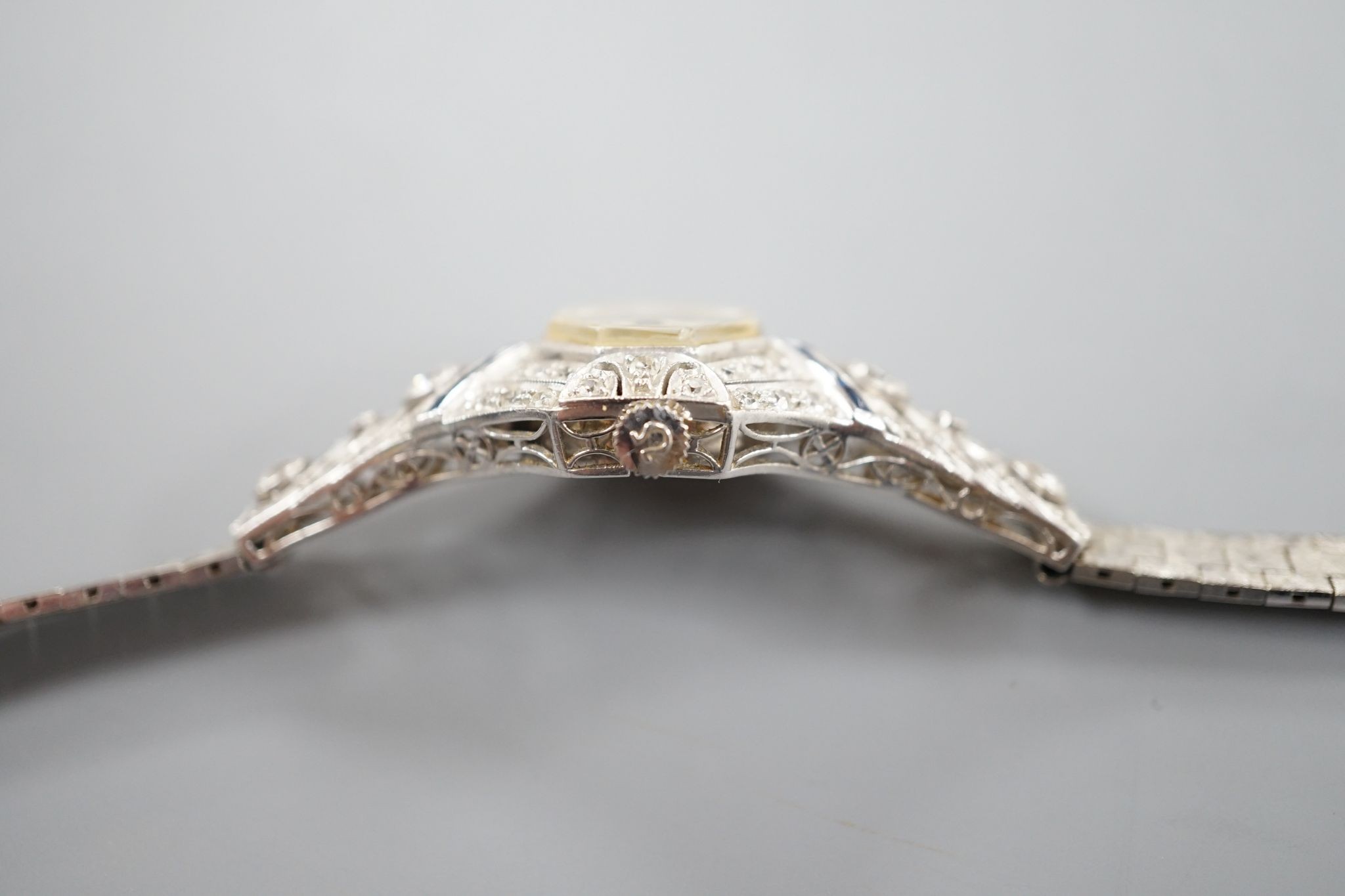 A mid 20th century white metal, synthetic sapphire? and diamond set cocktail watch, with Bucherer manual wind movement and dial bearing the signature Cartier, on a 14k white metal bracelet, case diameter 22mm, gross weig